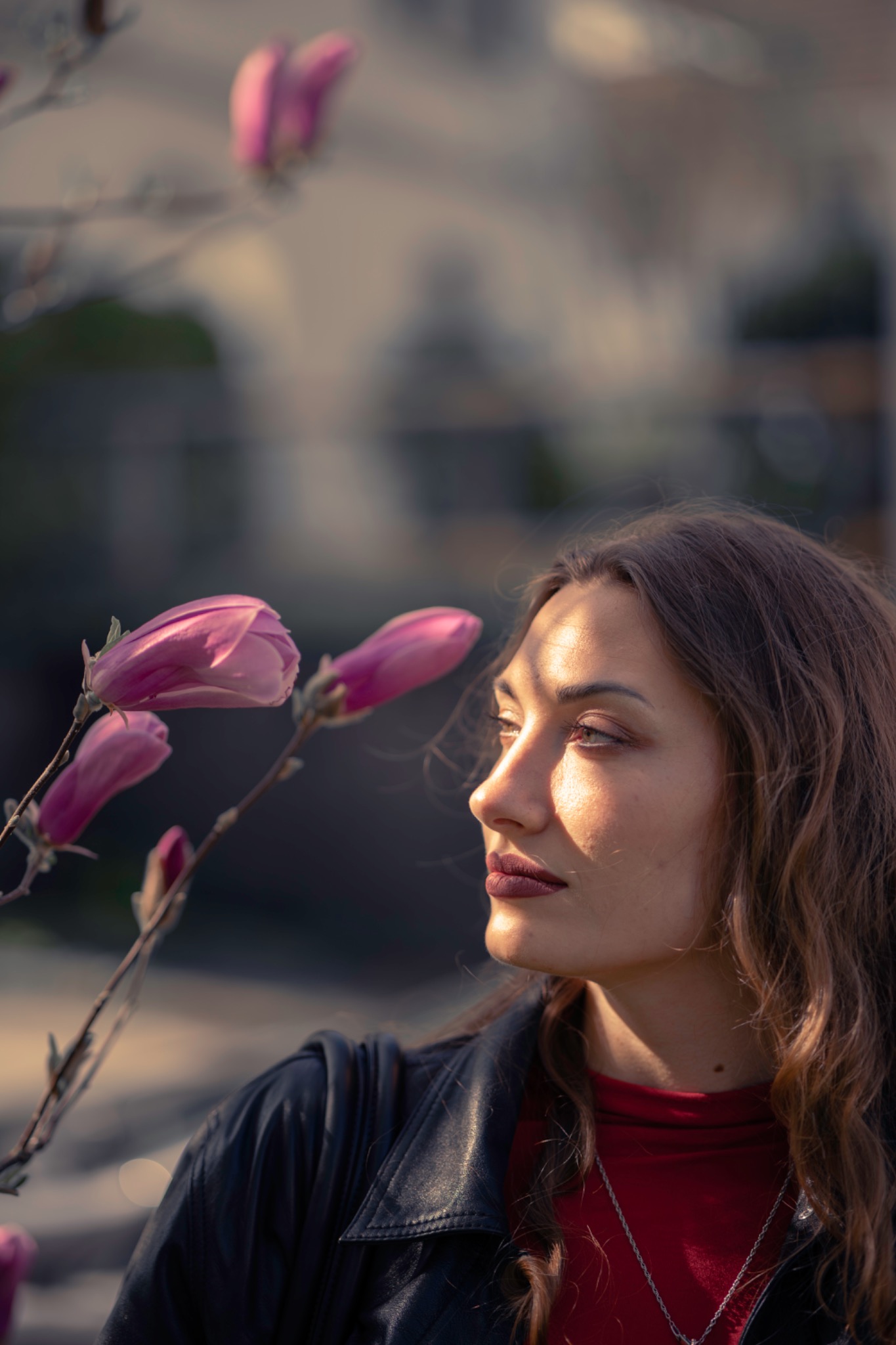 Profile of a woman beside pink magnolia flowers