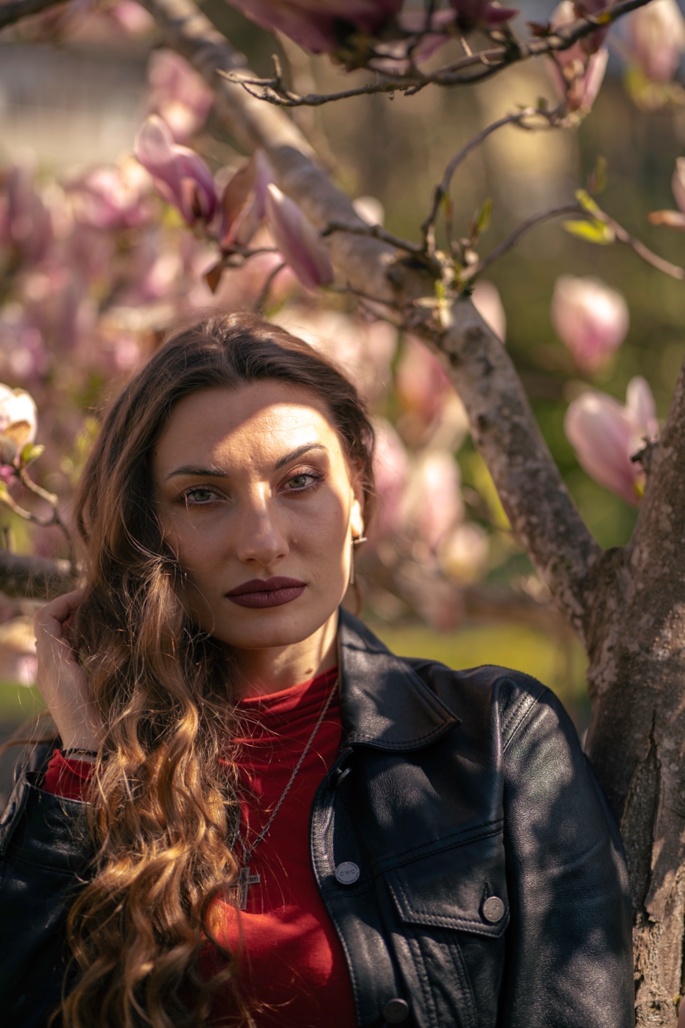 Portrait of a woman among blooming magnolia
