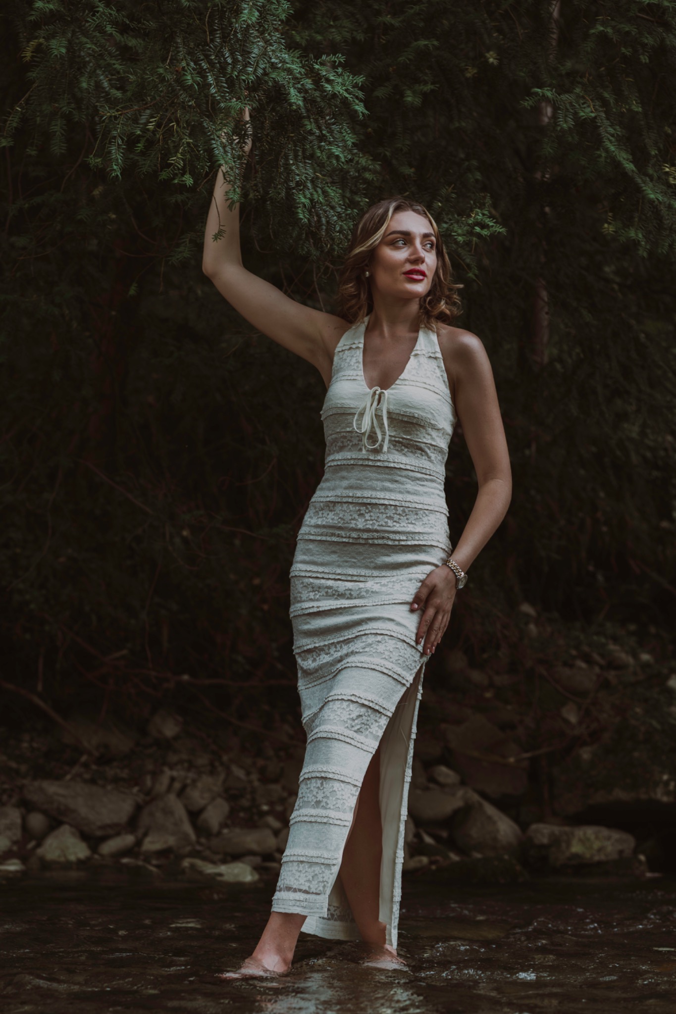Woman in a white dress against a dark forest