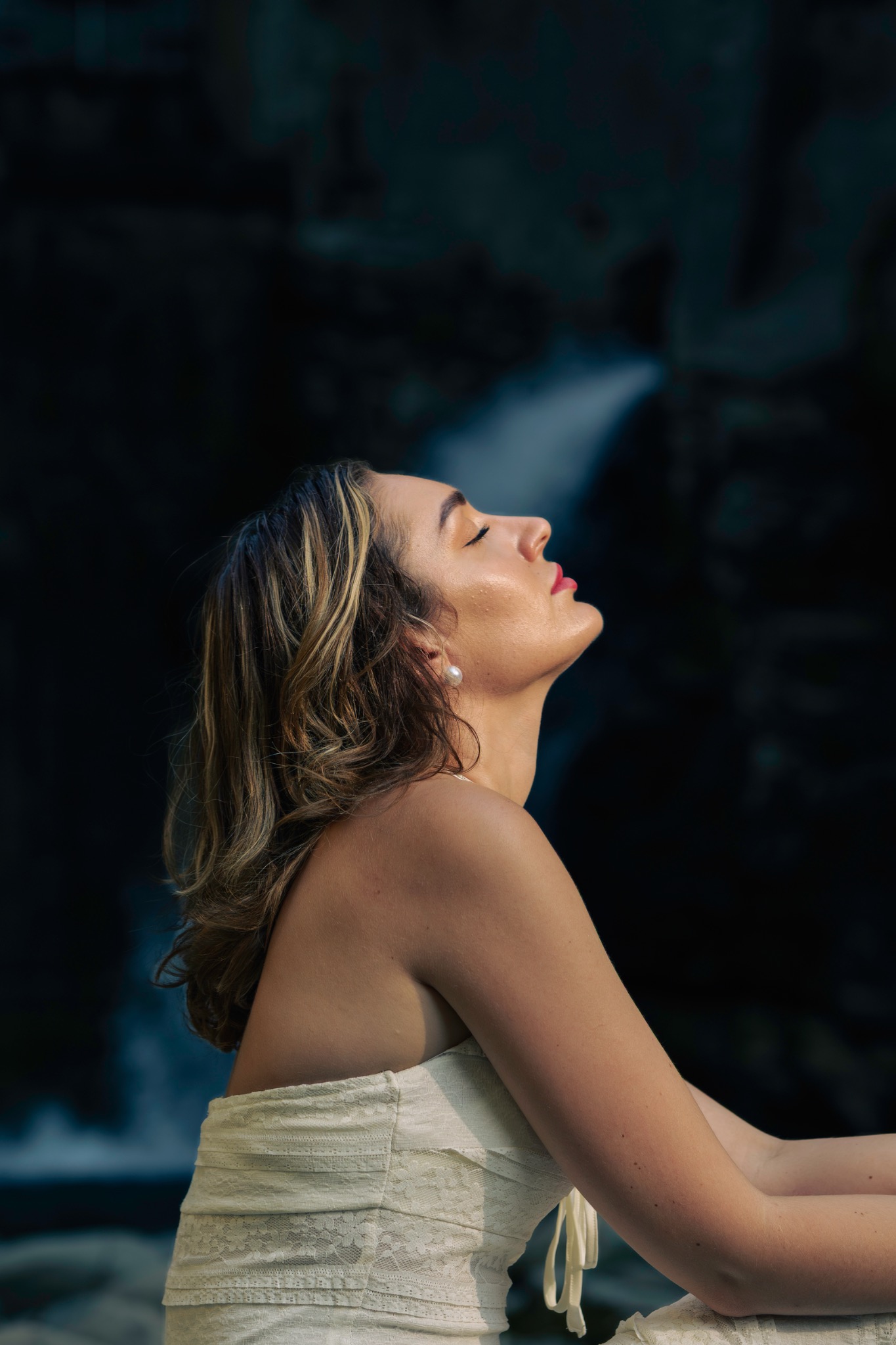 Profile of a woman in a white dress against a dark background